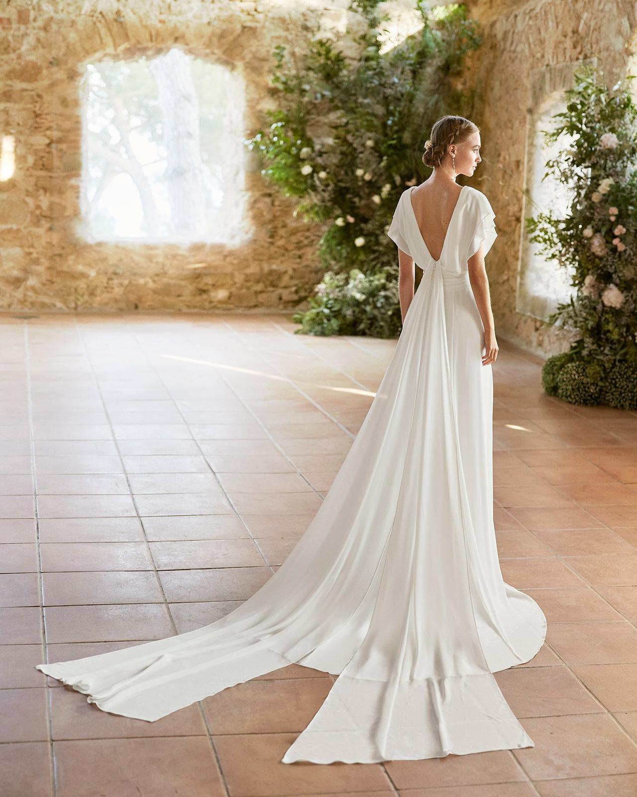 vestido de novia con cola y caídas vaporosas que nacen desde la espalda