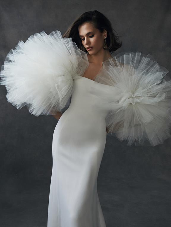 Chica con un vestido de novia de corte recto y liso, pero con unas espectaculares mangas de tul de forma esférica