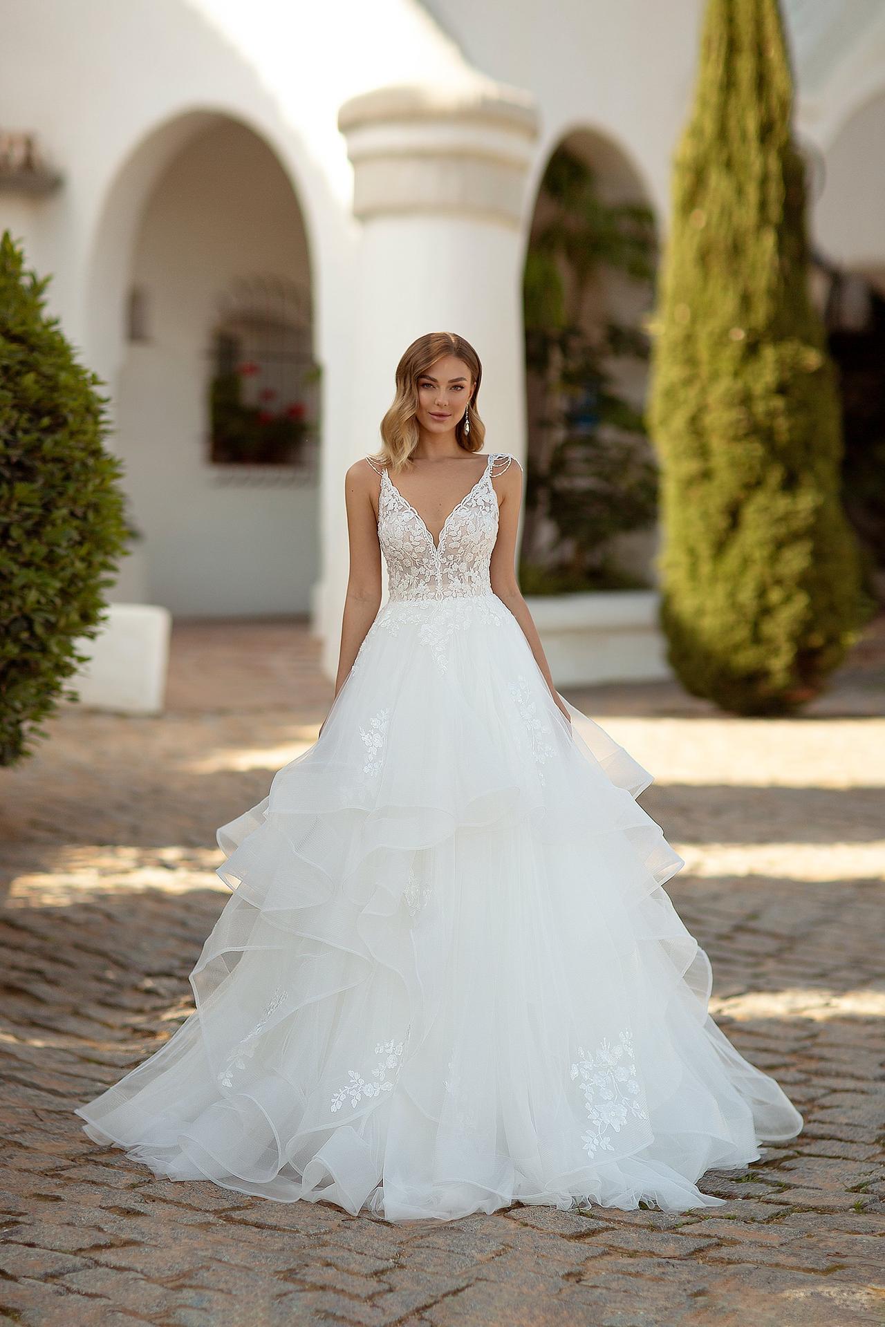 Vestido de novia de corte princesa con tirantes, escote en V y falda con volantes