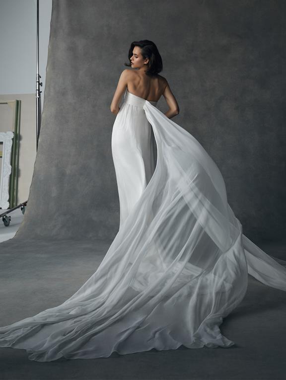 Chica de espaldas con un vestido de novia liso con dos colas