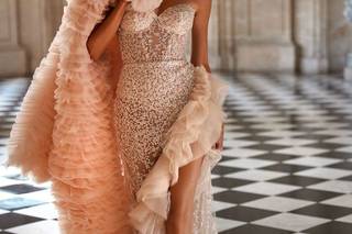 Chica con un vestido de novia blanco y una capa en Peach Fuzz