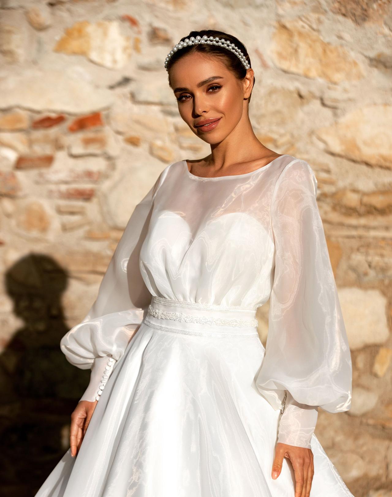 Vestido de novia con escote ilusión y mangas de poeta