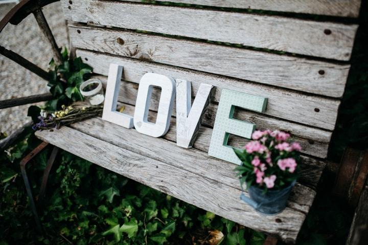 Letras con diferentes estampados decorativos formando la palabra Love en un rincón el día de la boda