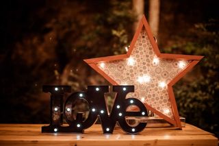 Letras con iluminación formando la palabra Love en un rincón decorativo el día de la boda