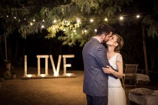 Grandes letras con iluminación en la base en las que puede leerse la palabra Love el día de la boda