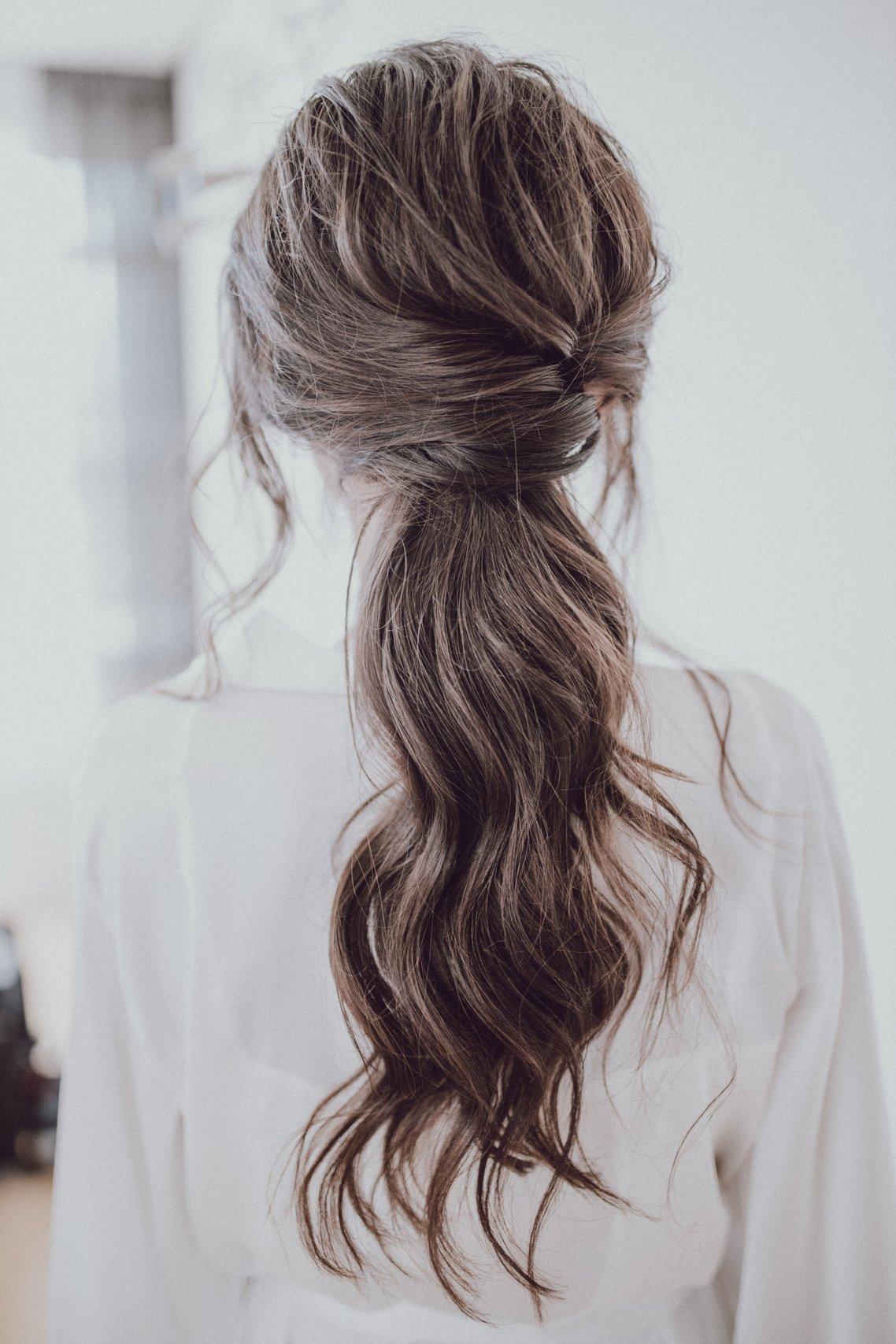 Chica morena de espaldas con el pelo largo y con ondas, recogido