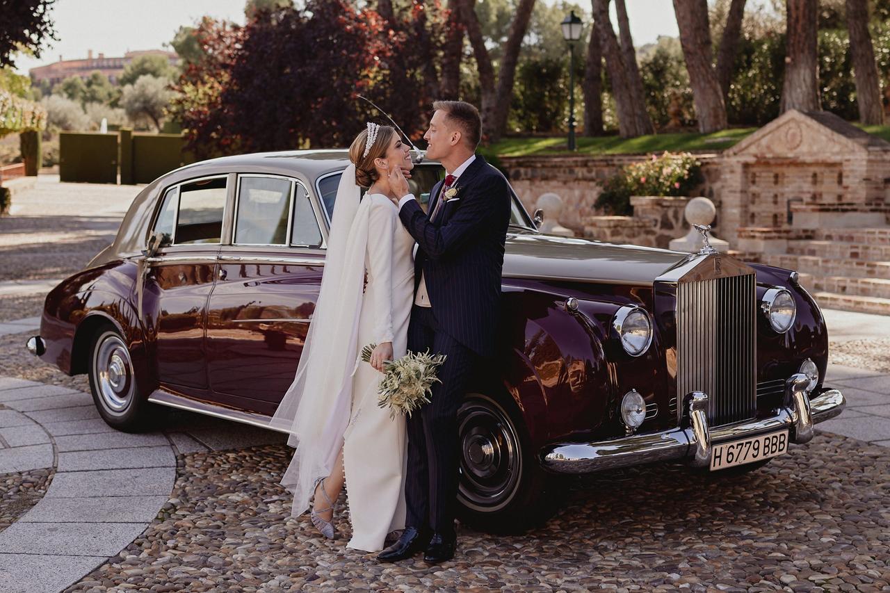 Enamorarse de ti: pareja de recién casados el día de la boda junto al coche de novios