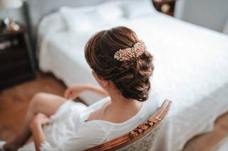 Chica sentada en una silla con el pelo recogido en un moño y decorado con un tocado