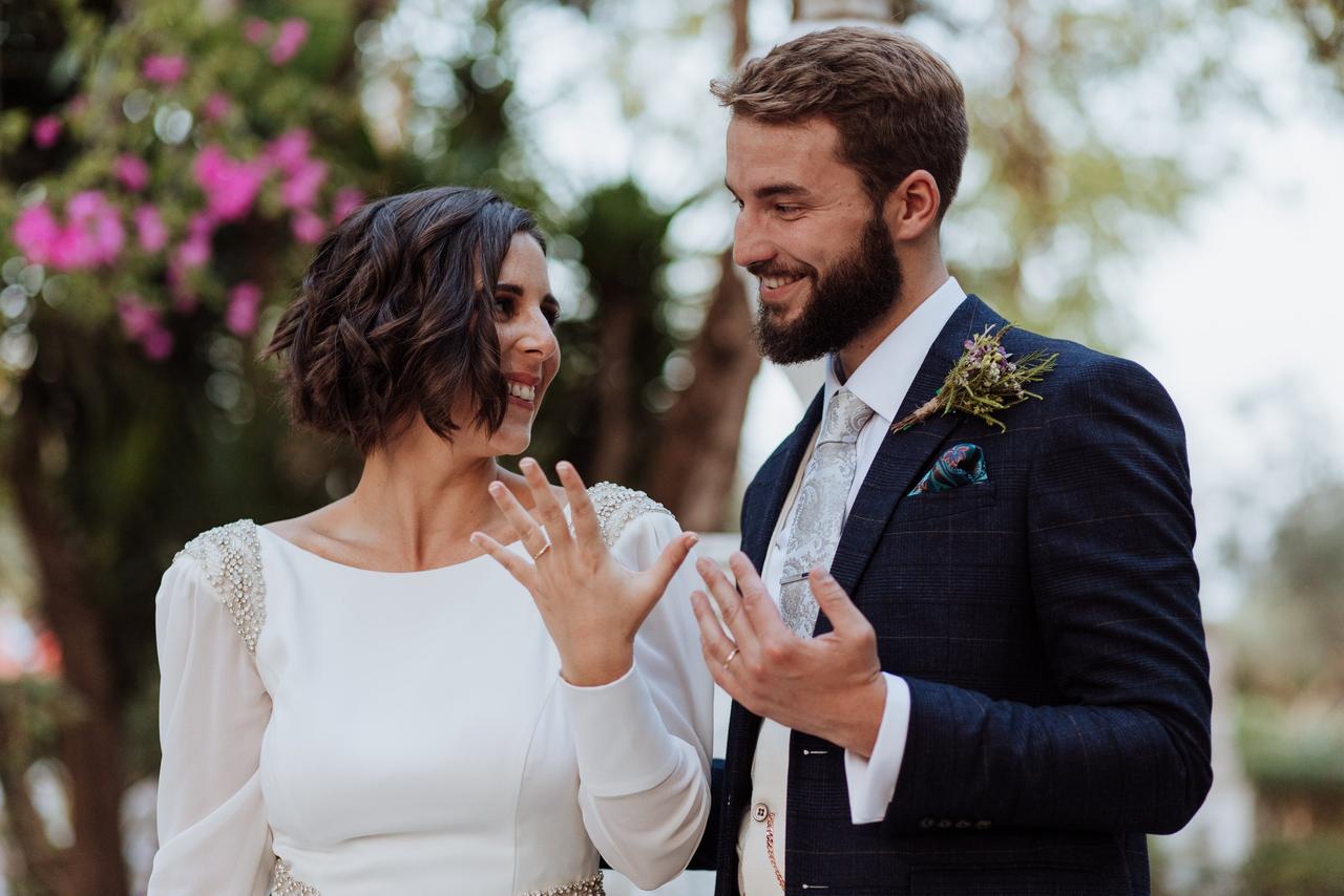 Hombre con barba y chica con peinado de novia pelo corto suelto mirándose a los ojos