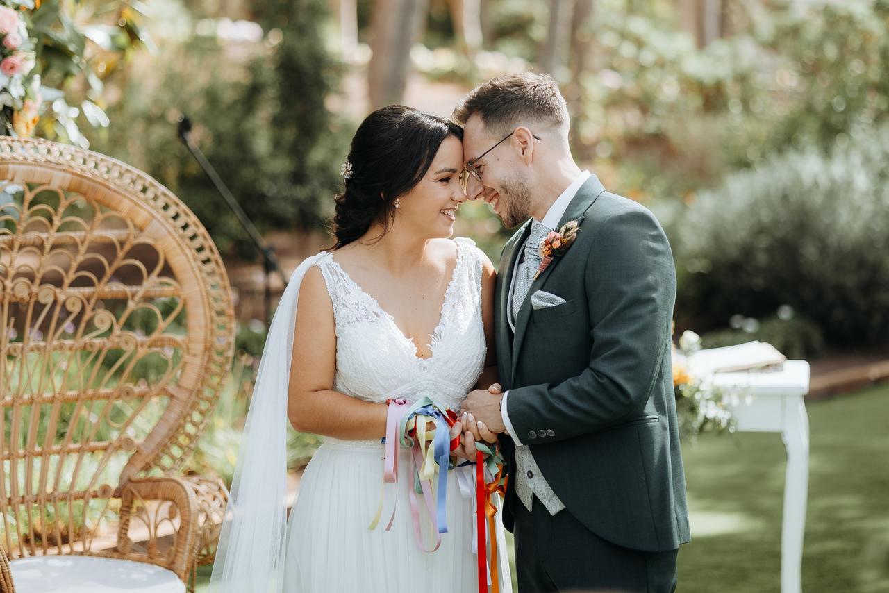 Handfasting: pareja feli durante la ceremonia del handfasting o unión de manos en su boda civil al aire libre