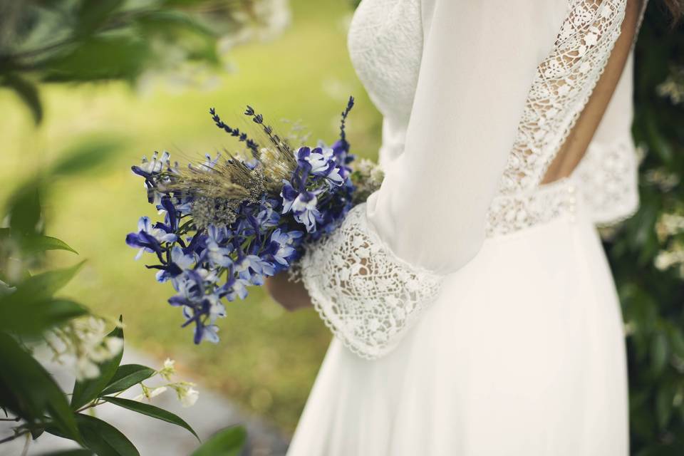 Novia sujetando su ramo de novia con flores de color azul