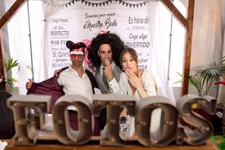 Ideas photocall boda: recién casados e invitado haciéndose una foto divertida