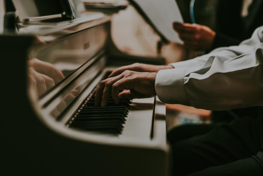 primer plano de unas manos tocando un piano