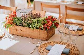 Centro de mesa de primavera con flores en una caja de madera reciclada