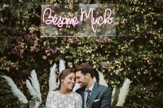 Pareja muy sonriente y feliz debajo de una frase luminosa que pone 