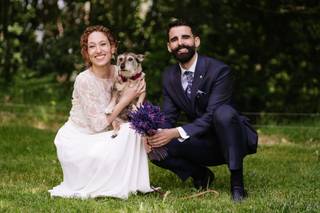 Perros en bodas: recién casados posan con su perro en brazos en un jardín