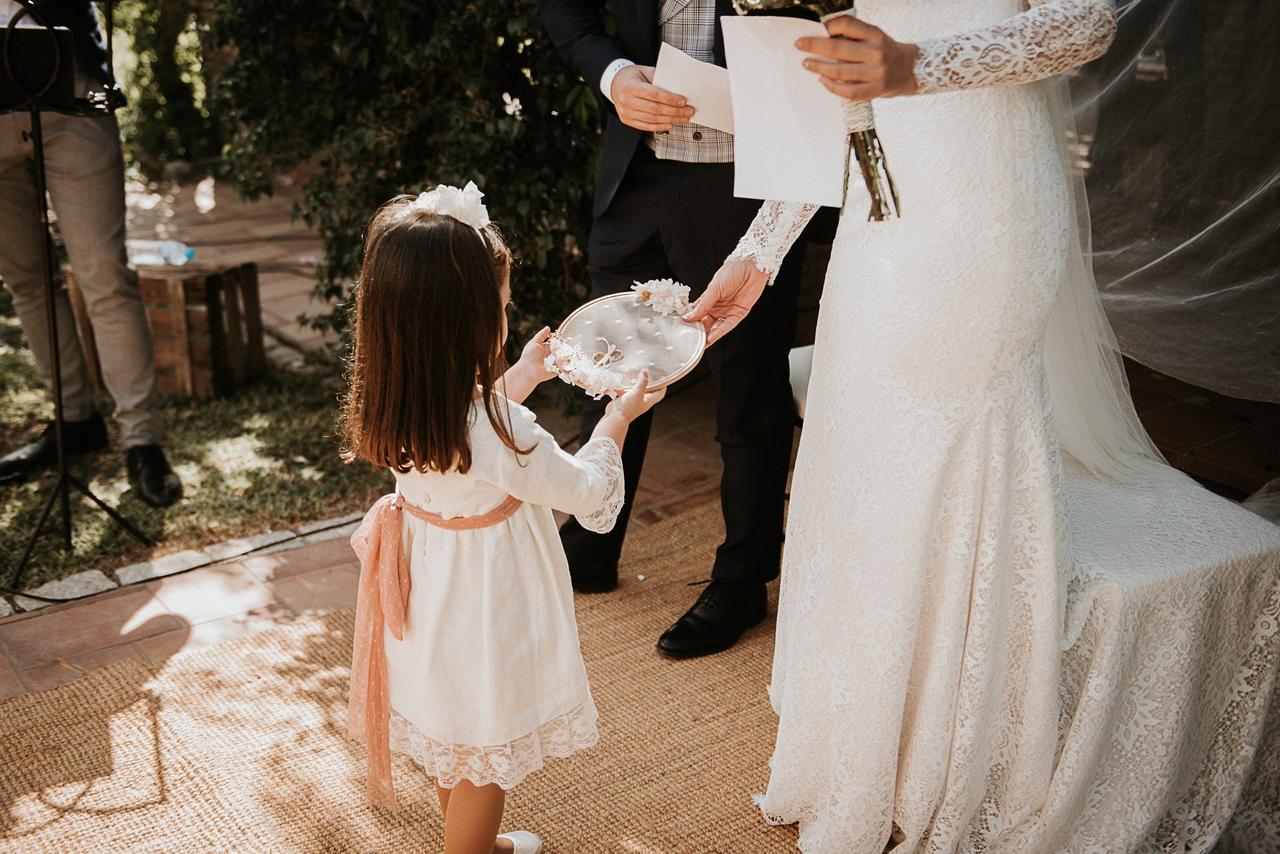 Paje de boda entregando el porta alianzas a la novia en el altar