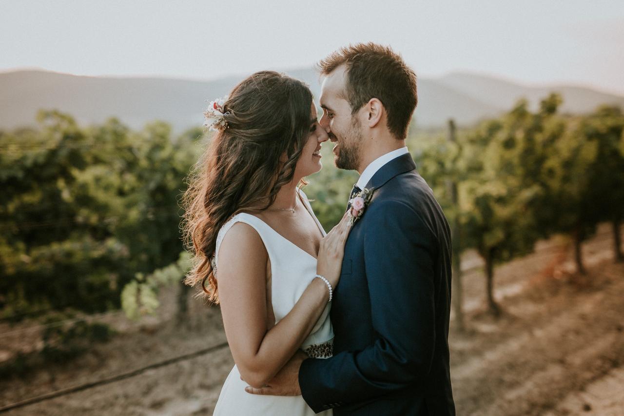 Chico y chica mirándose a los ojos en mitad de un viñedo