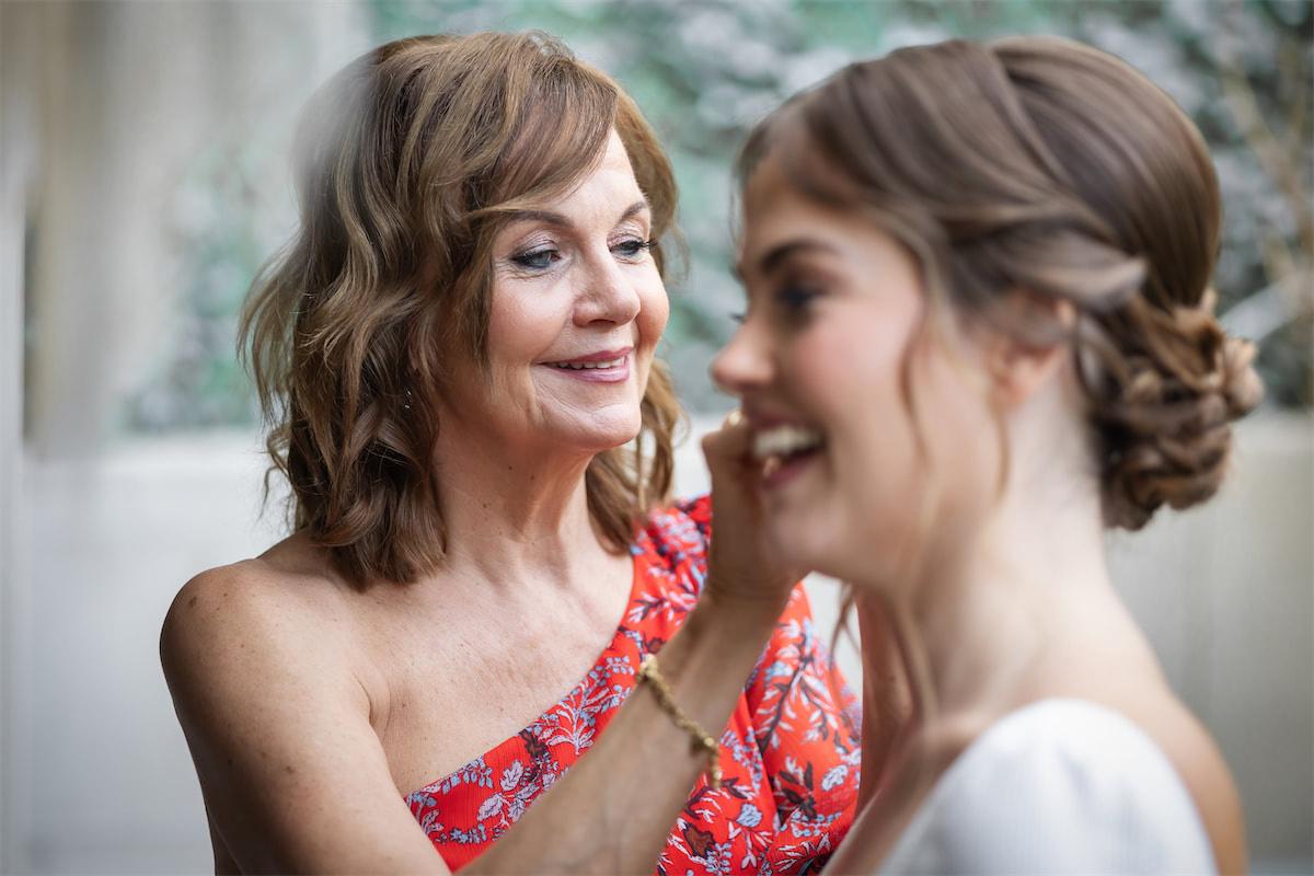 La madre de la novia: madre colocando bien el pelo a su hija vestida de novia