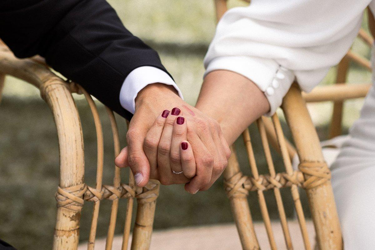 Casarse ante notario: mano de hombre y mujer entrelazadas durante su ceremonia de boda civil