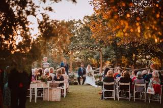 Pareja sentada en el altar de su ceremonia civil al aire libre delante de todos sus familiares y amigos