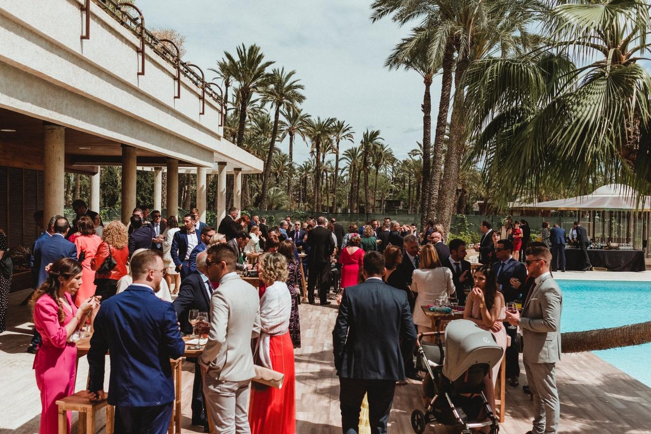 invitados de boda charlando entre ellos durante el aperitivo en un entorno al aire libre con piscina