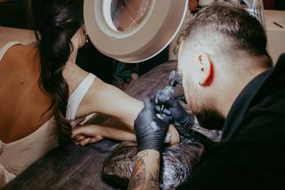 Ideas originales para bodas: tatuador tatuando el brazo de la novia