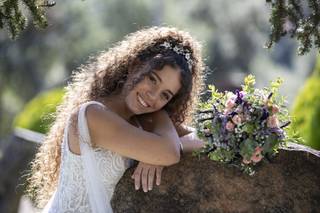 Peinados invitada boda pelo rizado: trenza en pelo moreno rizado con flores