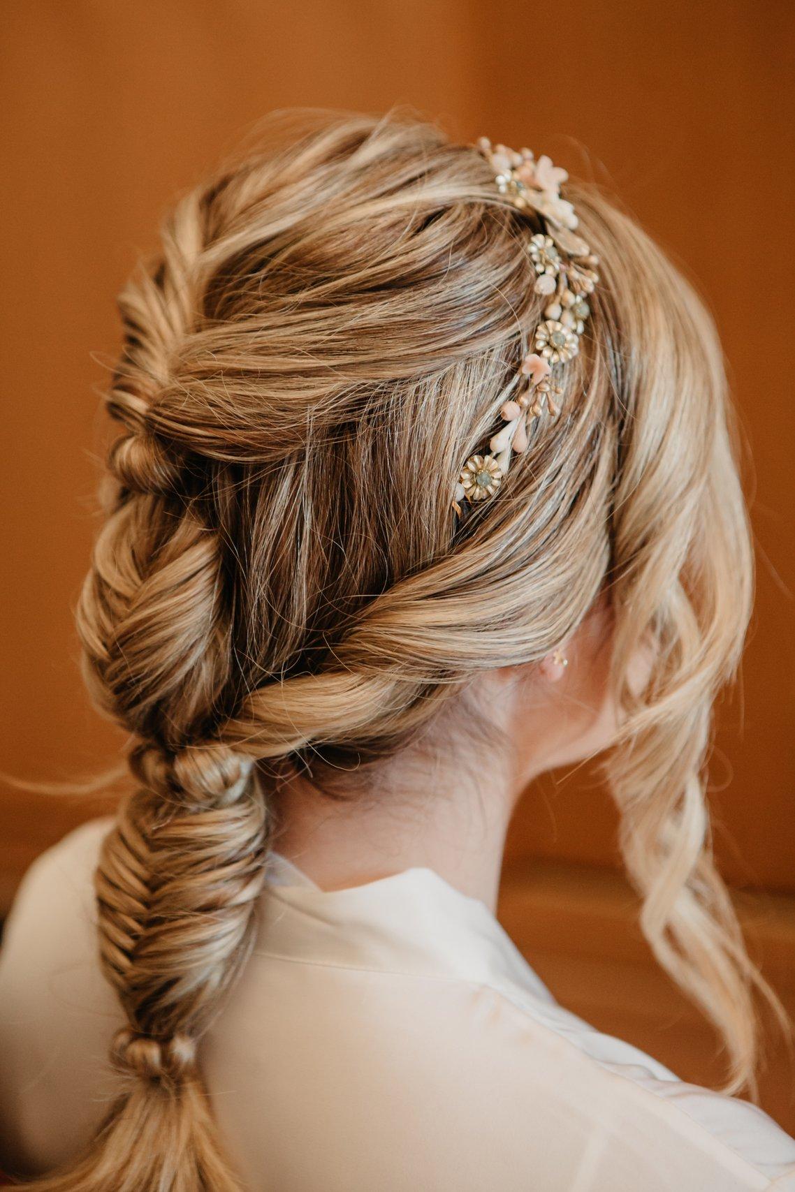 Peinado trenza: novia con una trenza de efecto messy con diadema de flores