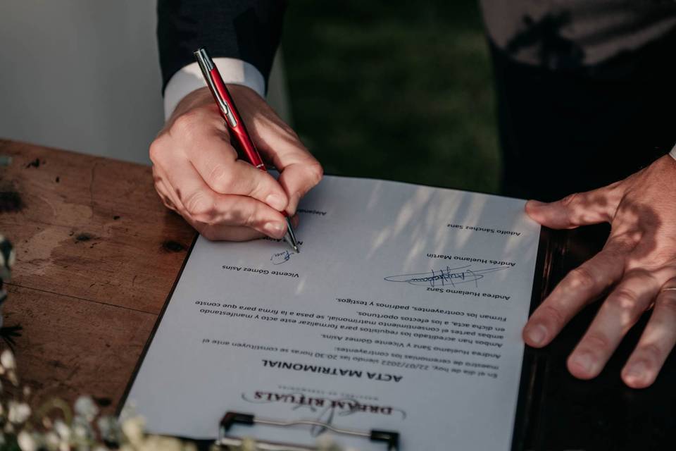 Trámites para casarse: mano masculina firmando el acta matrimonial el día de la boda