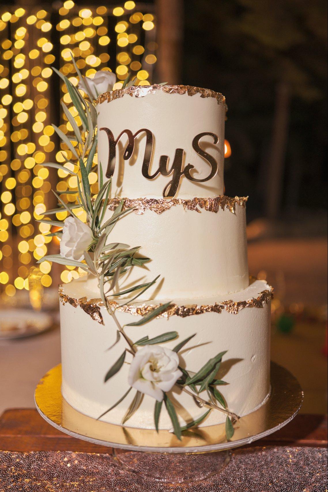 Tarta de boda de tres pisos con detalles dorados