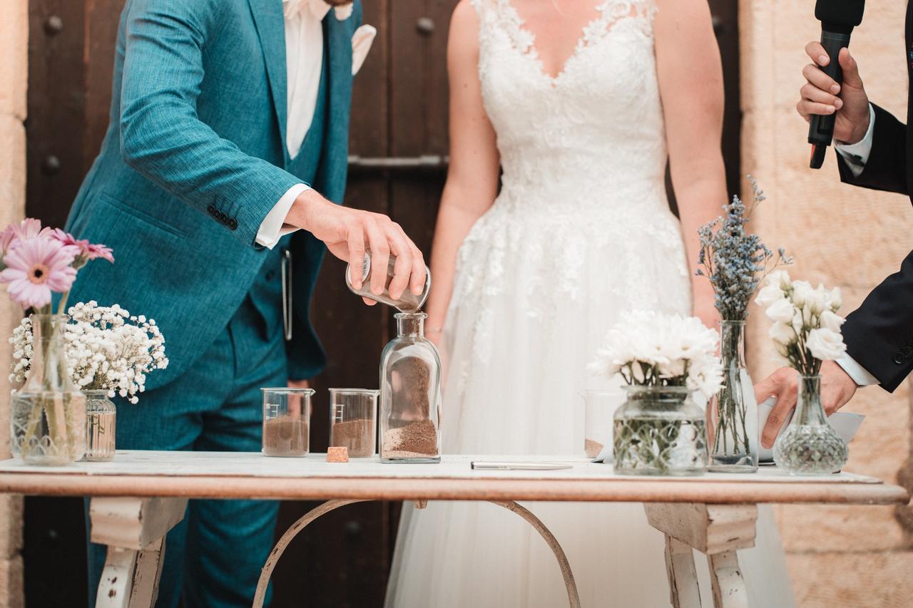 Ritual boda: pareja de chico y chica durante la ceremonia de la arena en su boda civil al aire libre