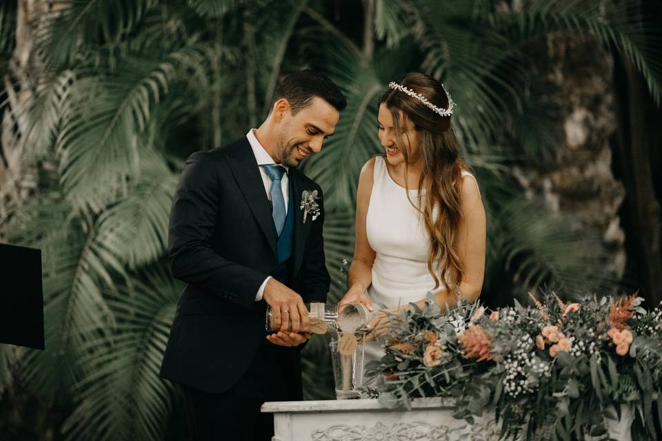 Pareja de chico y chica en el altar de su boda civil al aire libre durante la ceremonia de la arena