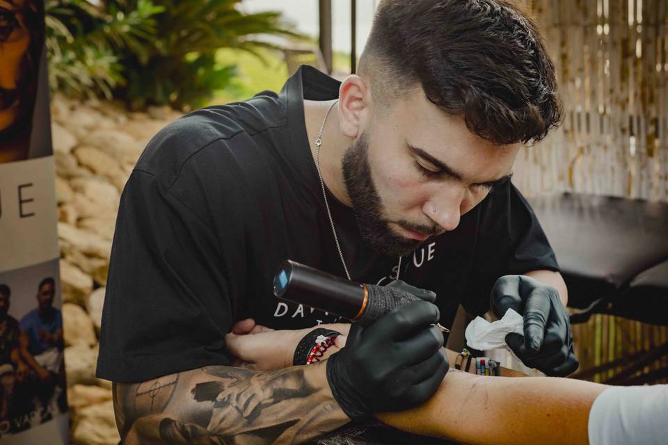 Barra libre tatuajes boda: tatuador profesional haciendo un tattoo en un brazo