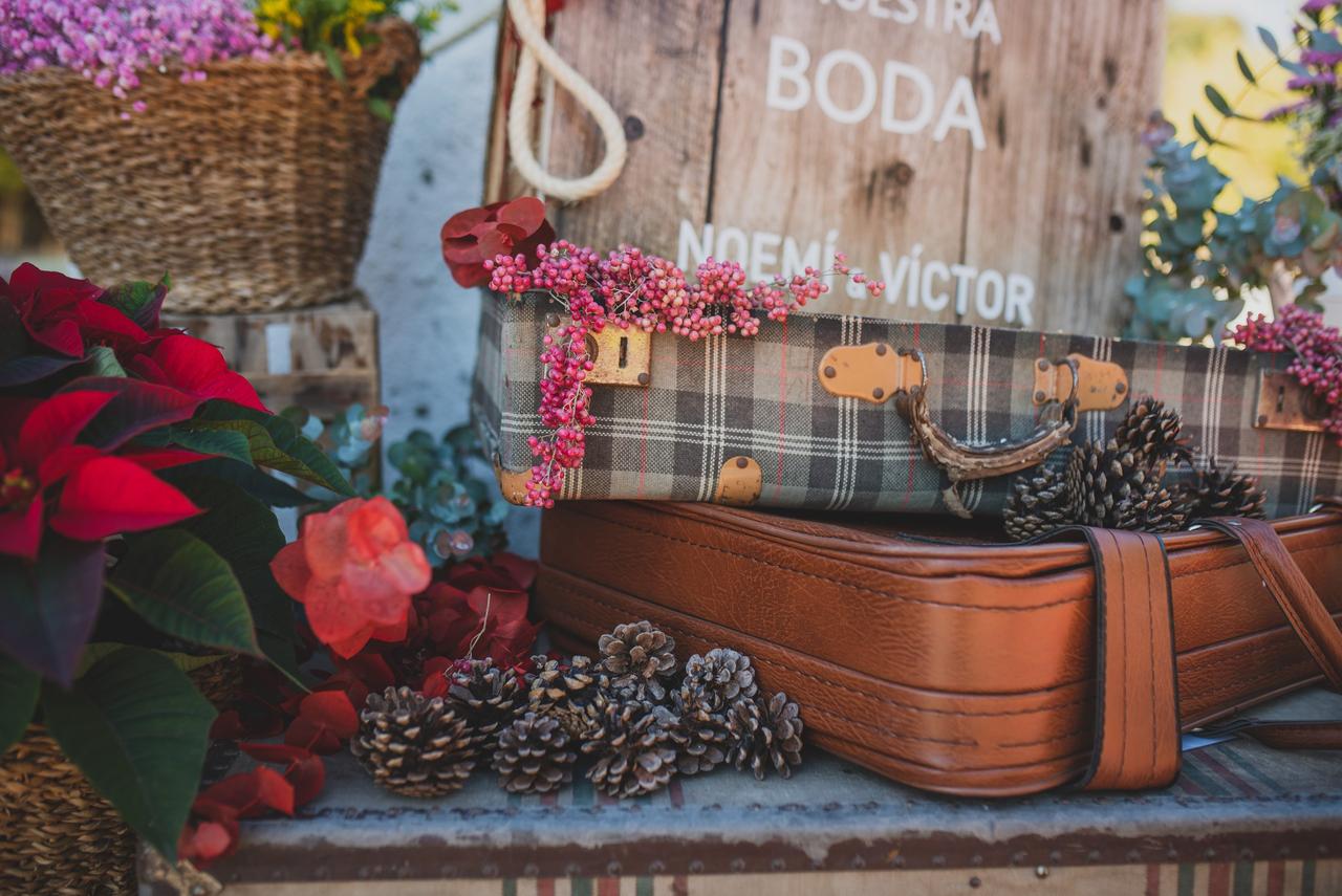 Maletas antiguas dan forma a un rincón con decoración de boda vintage