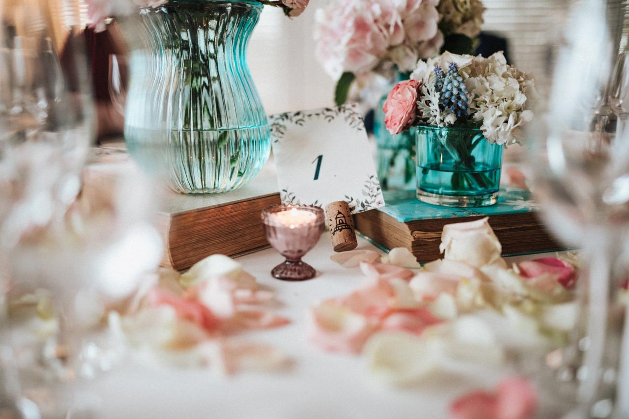 Decoración boda vintage: centro de mesa con jarrones de colores y libros antiguos