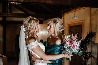 Madrinas de boda: madrina y novia se abrazan muy sonrientes, mirándose a los ojos