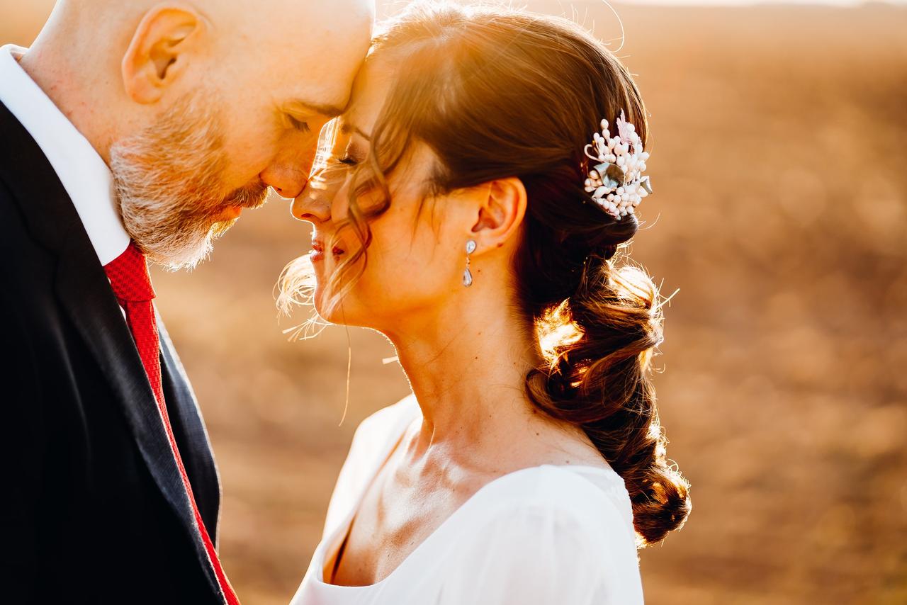 Coletas para bodas: novia con una coleta baja con aplique floral