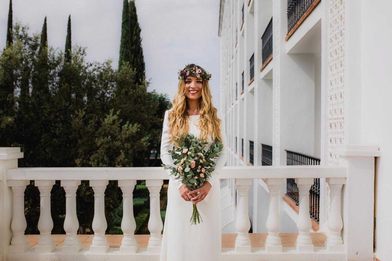 Novia con pelo largo y suelto, acompañado de una corona de flores, al aire libre