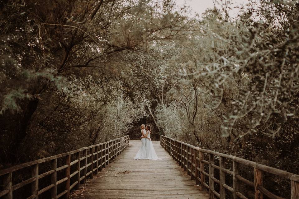 Fotos para hacerse en pareja: dos chicas vestidas de novia se abrazan en un puente