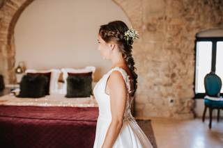 Peinado trenza: novia con el pelo recogido en una trenza con detalle floral