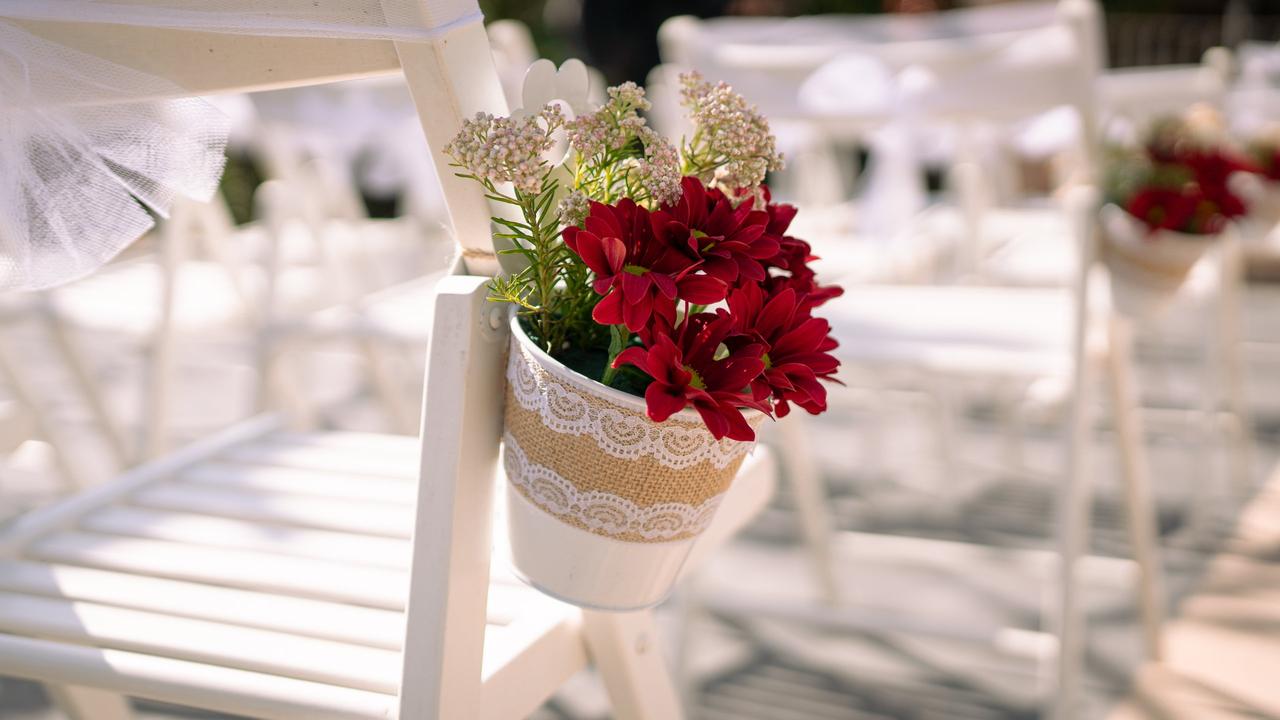 Macetas decorativas pequeñas vistiendo las sillas de la ceremonia civil el día de la boda