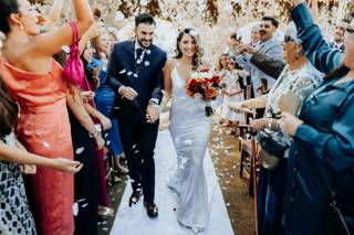 Frases más bonitas para felicitar a los novios: pareja caminando por el pasillo de su ceremonia civil al aire libre