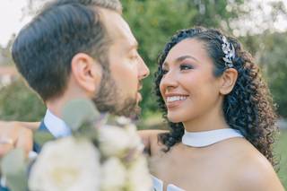 Peinados invitada boda pelo rizado: trenza en pelo moreno rizado con raya lateral y tocado