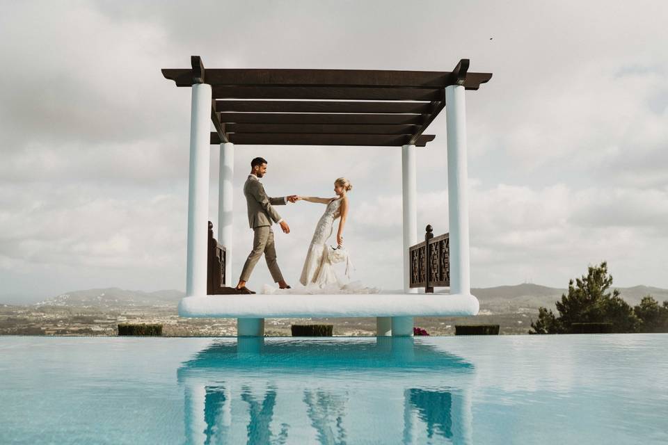 Pareja de recién casados baila junto a una piscina completamente solos