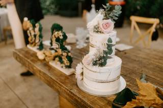 Tarta de boda con flores y hojas verdes