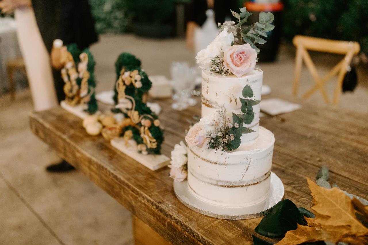 Tarta de boda con flores y hojas verdes