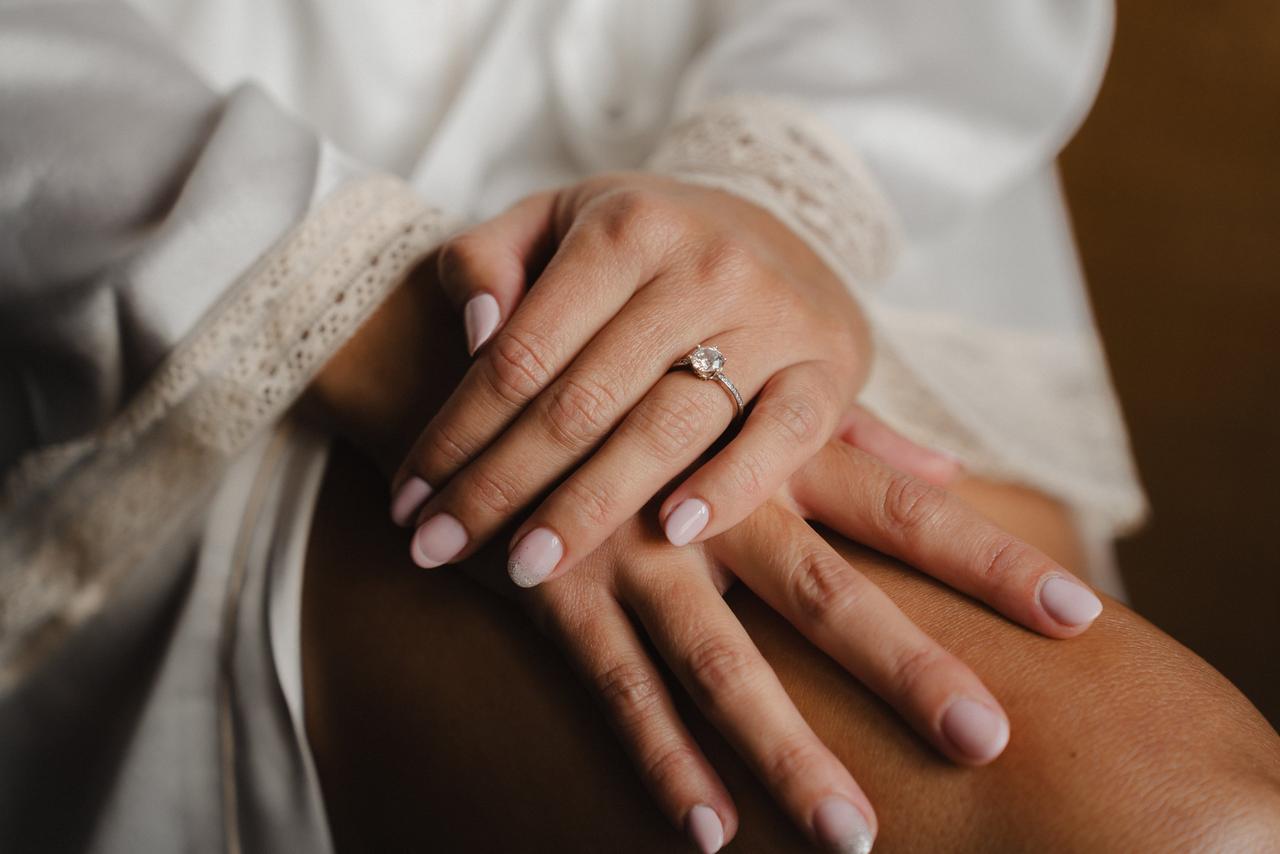 Cómo elegir anillo de compromiso: mano de mujer con anillo de compromiso con solitario central
