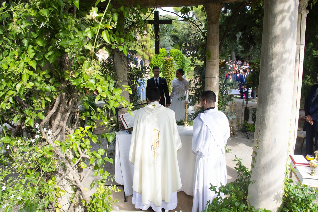 Sacerdote de espaldas oficiando una boda religiosa fuera de la iglesia en España