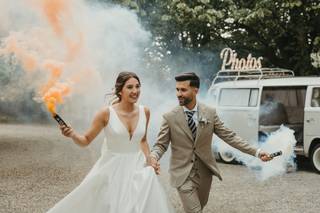 Ideas originales para bodas: pareja de recién casados con bengalas de humo de distintos colores en las manos
